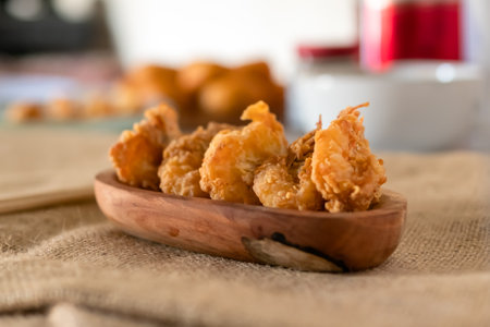 Crispy prawns served on a wooden plate in a traditional kitchen compositionの写真素材