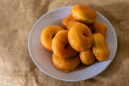 Traditional snack donuts on white plate in kitchen compositionの写真素材