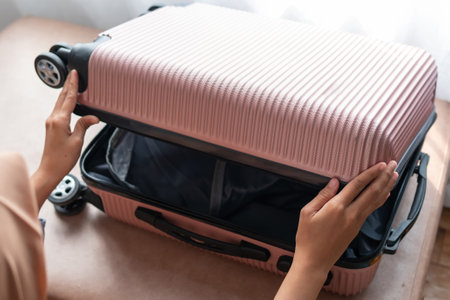 Woman packing suitcase for travel, adventure and vacation in bed before leaving for vacation.の写真素材