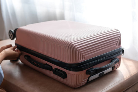 Pink suitcase on hotel bed. travel conceptの写真素材