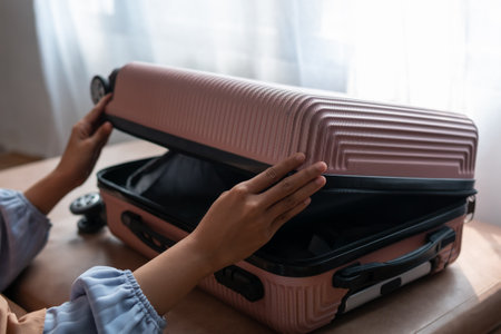 Woman packing suitcase for travel, adventure and vacation in bed before leaving for vacation.の写真素材