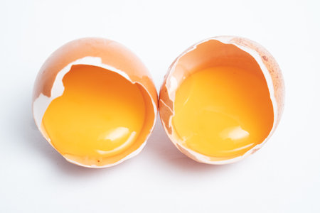 Separated egg yolk in shell isolated on white background, Macro shot