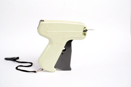 Beige etiquette gun with needle isolated on white background