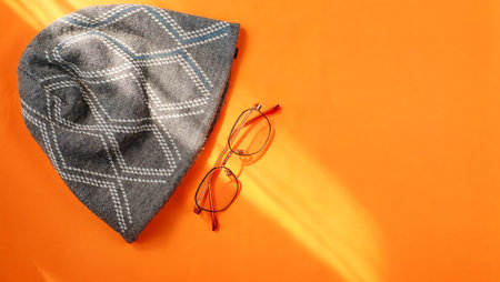 Top view of autumn fashion, Beanie hat and trendy sunglasses on orange background, Autumn conceptの写真素材