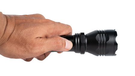 Black LED flashlight in male hand isolated on white backgroundの写真素材