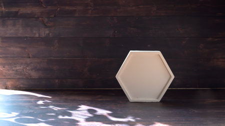 White polygon concrete podium on old wooden background with shadow for cosmetic products and...