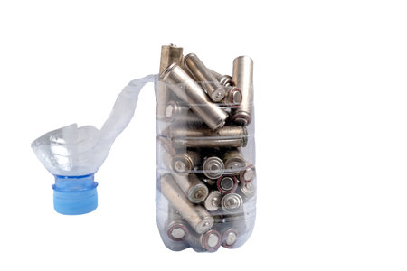 Waste alkaline battery in plastic bottle on white background. Chemical waste.