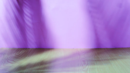 Wooden table and shadow of palm leaves on purple wall. Abstract background.の写真素材
