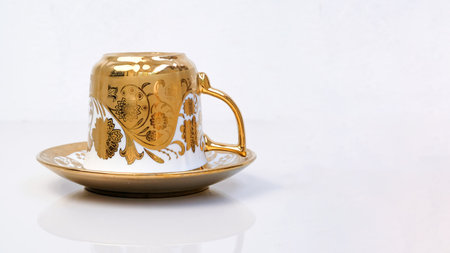 Antique porcelain coffee cup on white background with reflection.の写真素材