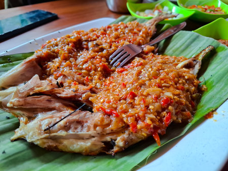 Grilled Fish Topped with Spicy Chili Sauce on a Leaf Platterの写真素材