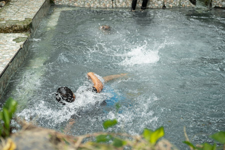 Children Having Fun In A Refreshing Outdoor Poolの写真素材