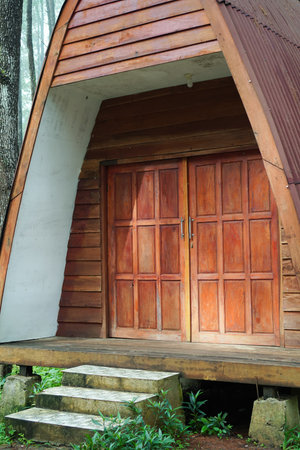 Rustic Wooden Cabin Exterior With Brown Door And Stone Stepsの写真素材