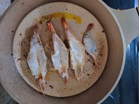 Raw prawns in a frying pan on the kitchen table.の写真素材