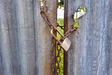 Old rusty padlock on a metal fence. The concept of security.の写真素材