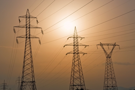 High voltage electricity pylons against sunsetの写真素材