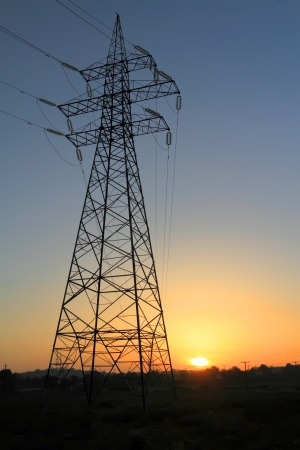 High voltage electricity pylon against sunsetの写真素材