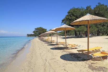 Umbrellas and recliners by the sea on exotic resort, Thassos island - Greeceの写真素材