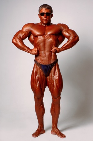 Muscled male model posing in studio on a light backgroundの写真素材
