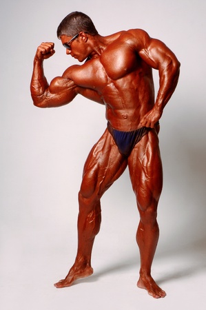 Muscled male model posing in studio on a light backgroundの写真素材