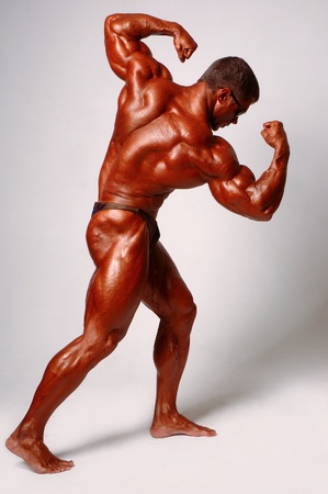 Muscled male model posing in studio on a light backgroundの写真素材