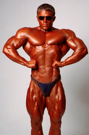Muscled male model posing in studio on a light backgroundの写真素材