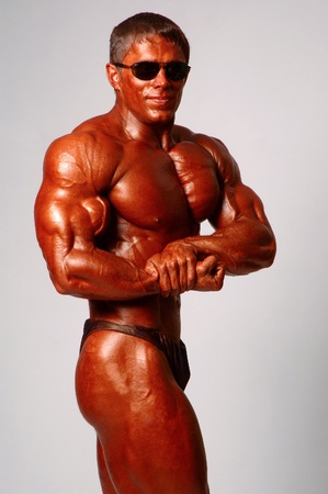 Muscled male model posing in studio on a light backgroundの写真素材