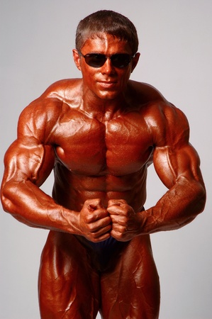 Muscled male model posing in studio on a light backgroundの写真素材