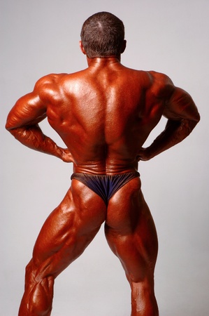 Muscled male model posing in studio on a light backgroundの写真素材
