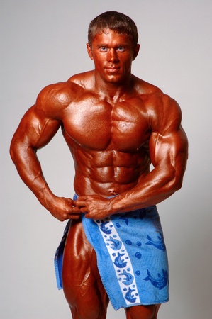 strong athletic man with a towel in handsの写真素材