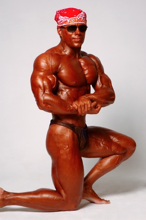 Muscled male model posing in studio on a light backgroundの写真素材