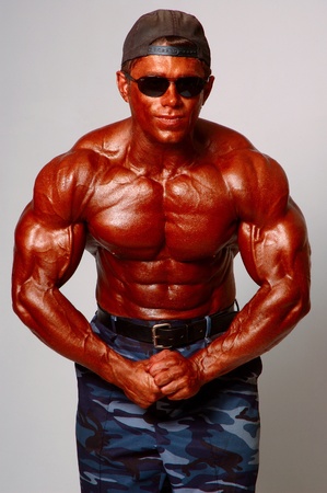 Brawny man in cap in a glasses on a light backgroundの写真素材