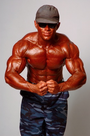 Brawny man in cap in a glasses on a light backgroundの写真素材