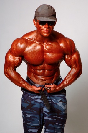 Brawny man in cap in a glasses on a light backgroundの写真素材