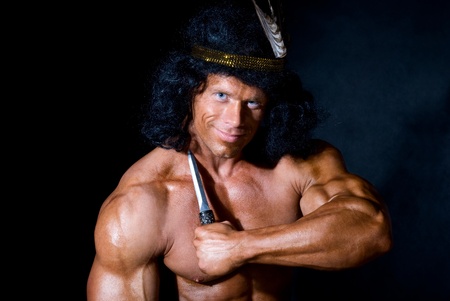 Strong athletic man with a knife on a black backgroundの写真素材