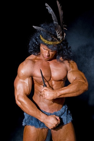 Strong athletic man with a knife on a black backgroundの写真素材