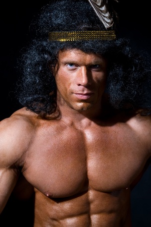 The athletic man with a feather on a head on a black backgroundの写真素材
