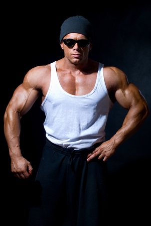 strong athletic man in dark glasses on a black backgroundの写真素材