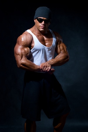 strong athletic man in dark glasses on a black backgroundの写真素材