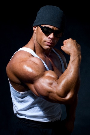 strong athletic man in dark glasses on a black backgroundの写真素材