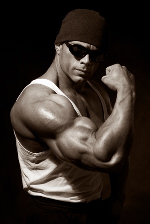 strong athletic man in dark glasses on a black backgroundの写真素材