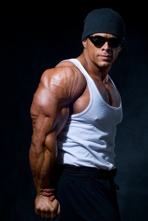 strong athletic man in dark glasses on a black backgroundの写真素材