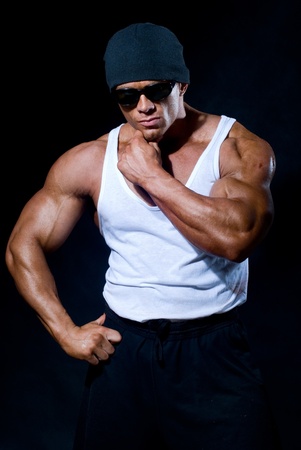 strong athletic man in dark glasses on a black backgroundの写真素材