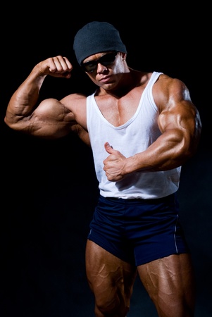 strong athletic man in dark glasses on a black backgroundの写真素材
