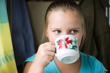 The girl drinks from a cup and distractsの写真素材