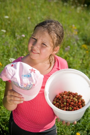 The girl who has sweated from a heat with a bucket with a strawberryの写真素材