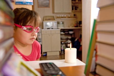 The girl wearing spectacles for swimming looks at a candleの写真素材