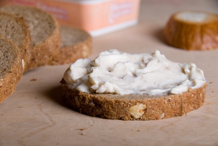 Piece of bread with a cheese cream on a wooden tableの写真素材