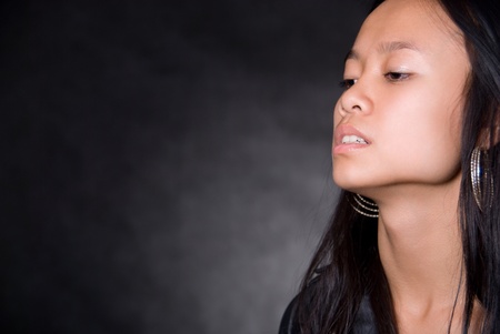 Portrait of girl with Asian appearance against a dark background