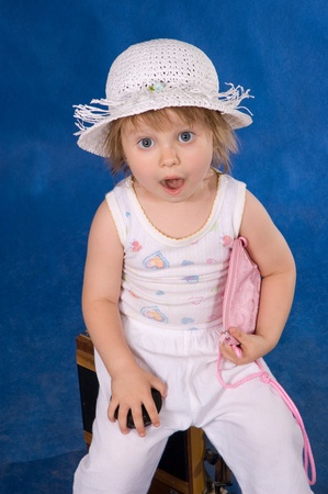The little girl in a hat on a dark blue backgroundの写真素材