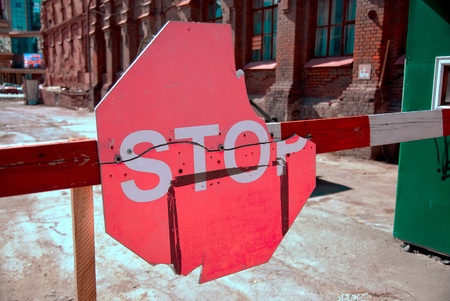 A red stop sign on a barrier 